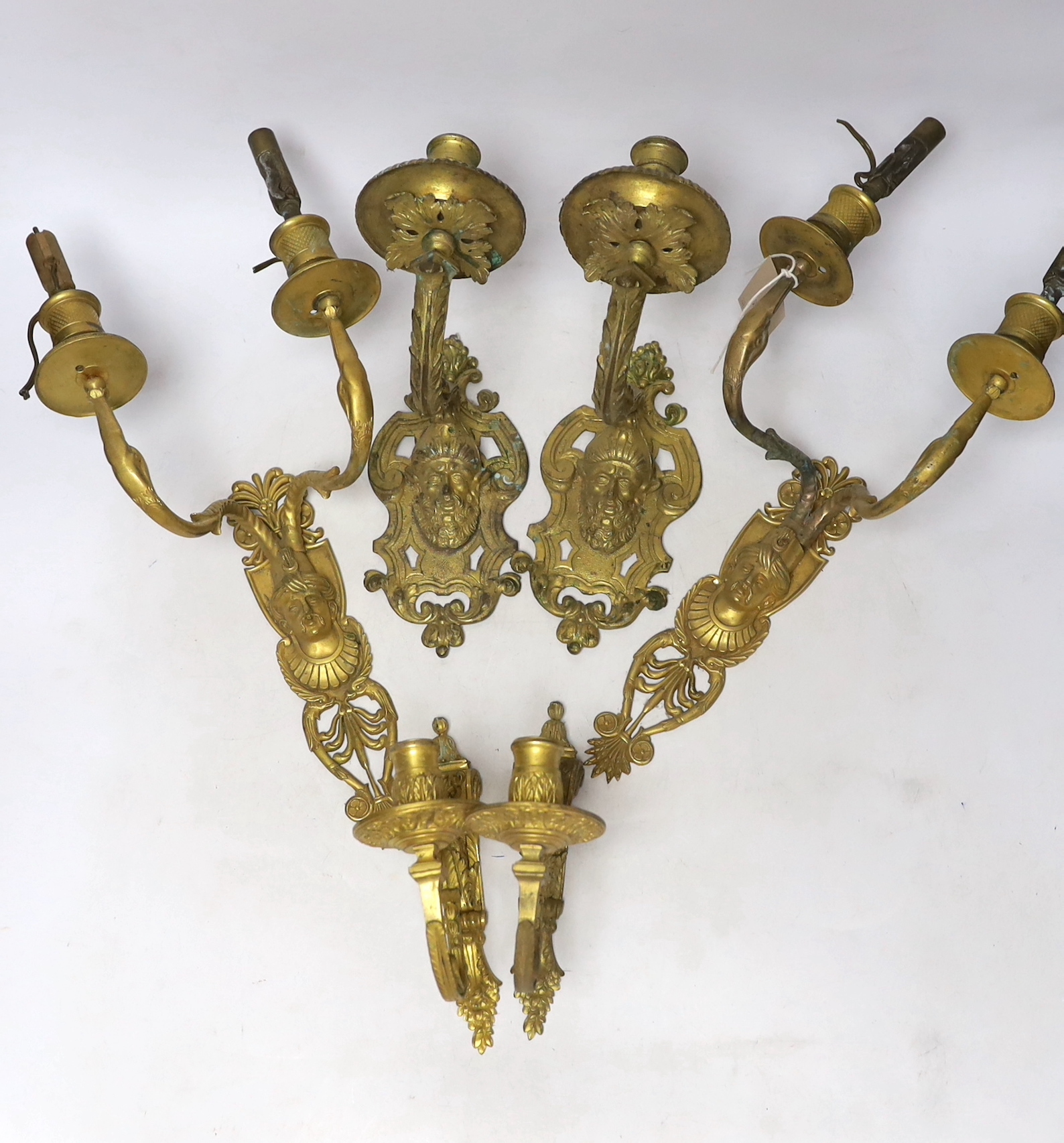 A pair of ormolu two branch wall lights, a pair of single branch mask wall lights and a small pair of wall lights, largest 32cm high